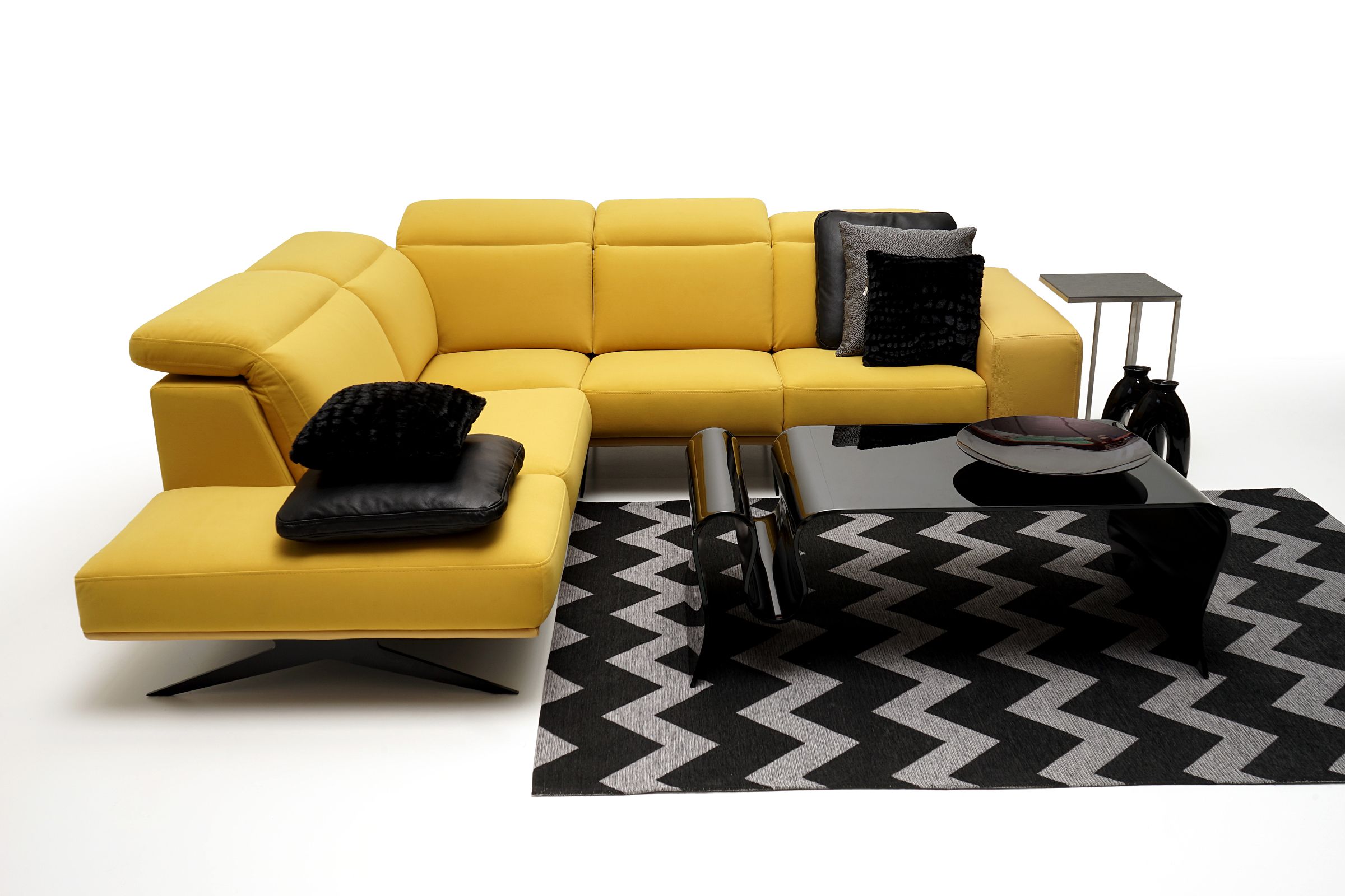 Giotto pomysł na urządzenie salonu z żółtą sofą czarnym dywanem i ławą szklaną