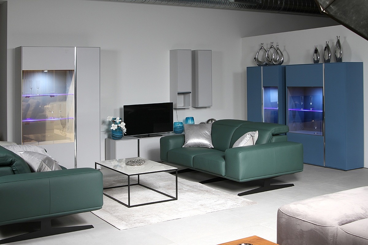 Laguna – aranżacja wnętrza nowoczesnego salonu z szarą i niebieską witryną oraz sofą w kolorze butelkowej zieleni