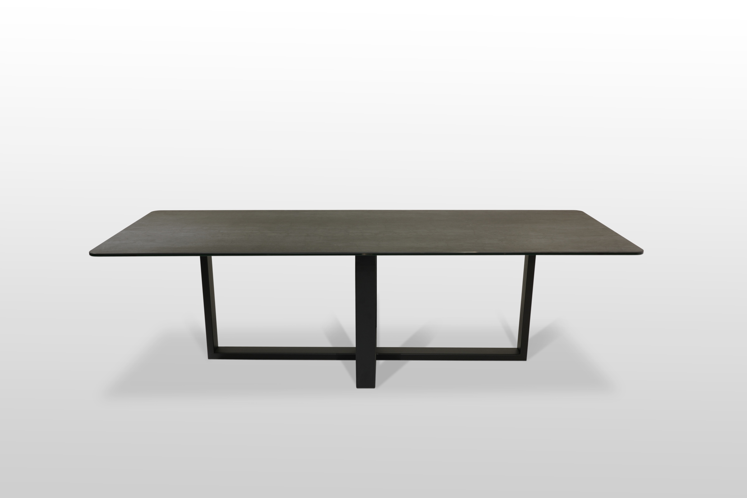 Stół nierozkładany ze spiekoweym blatem klejonym na szkle usytułowany na metalowej czarnej ramie