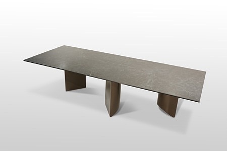 Nierozkładany stół ze spieku kwarcowego na trzech potężnych nogach. Stół ma kształt prostokata z ostymi rogami