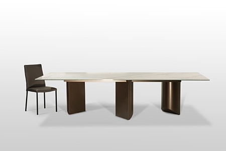 Nowoczesny, nierozkładany stół na trzech kolumnach w brązowym kolorze, z blatem ze spieku kwarcowego w białym kolorze. TC Meble z Dobrodzienia